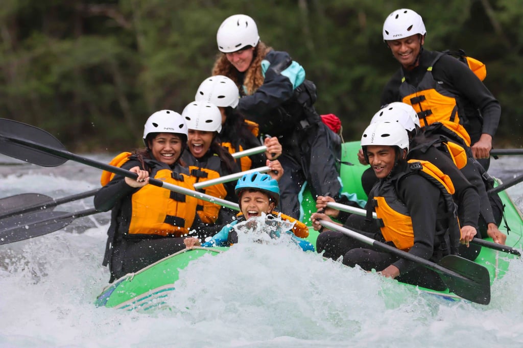 Family rafting adventure on turquoise river amid lush green forest, smiling and paddling.