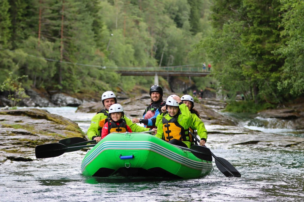 Family rafting adventure on turquoise river amid lush green forest, smiling and paddling.