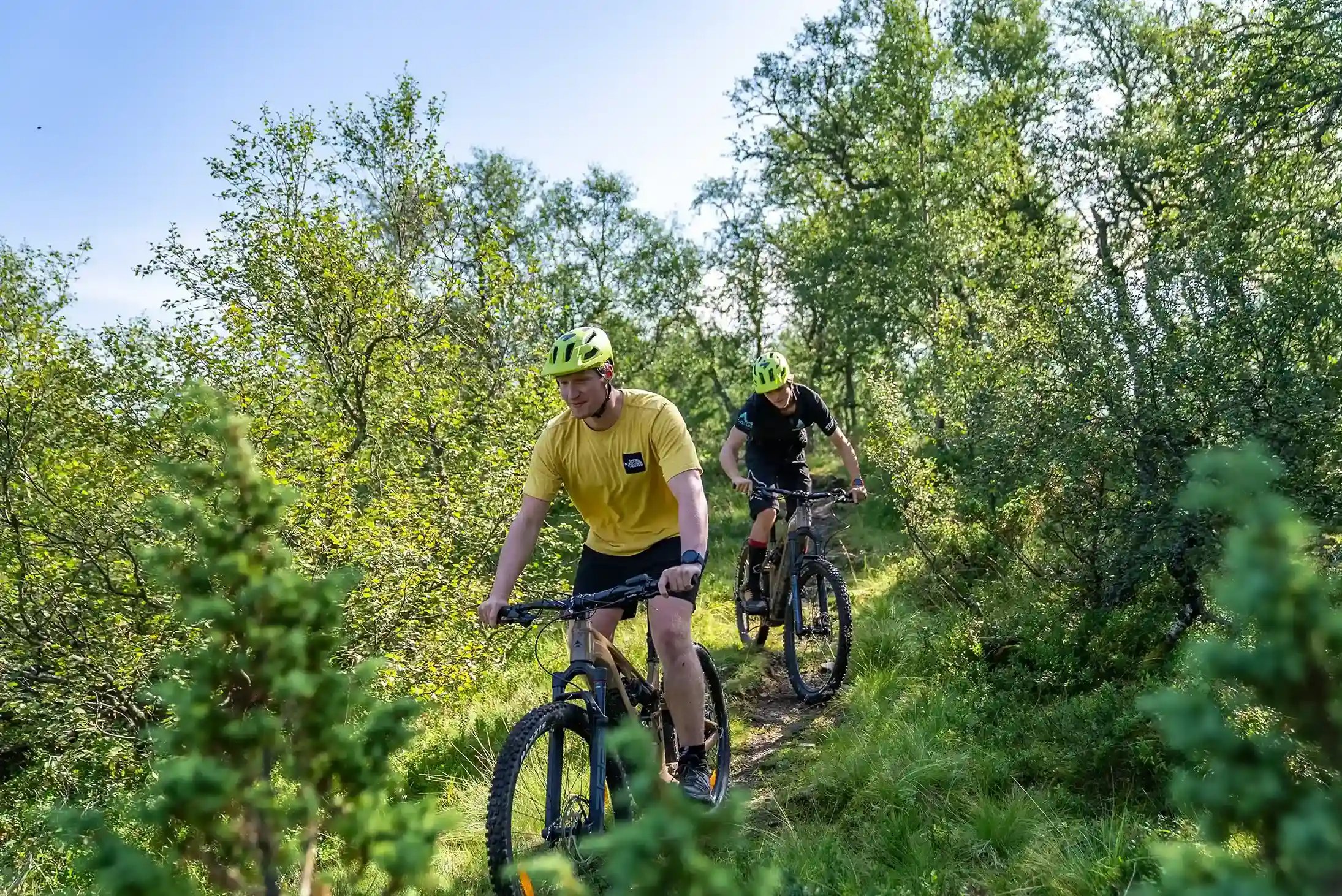 Two men on a mountain bike route in Norway following the cycling rules