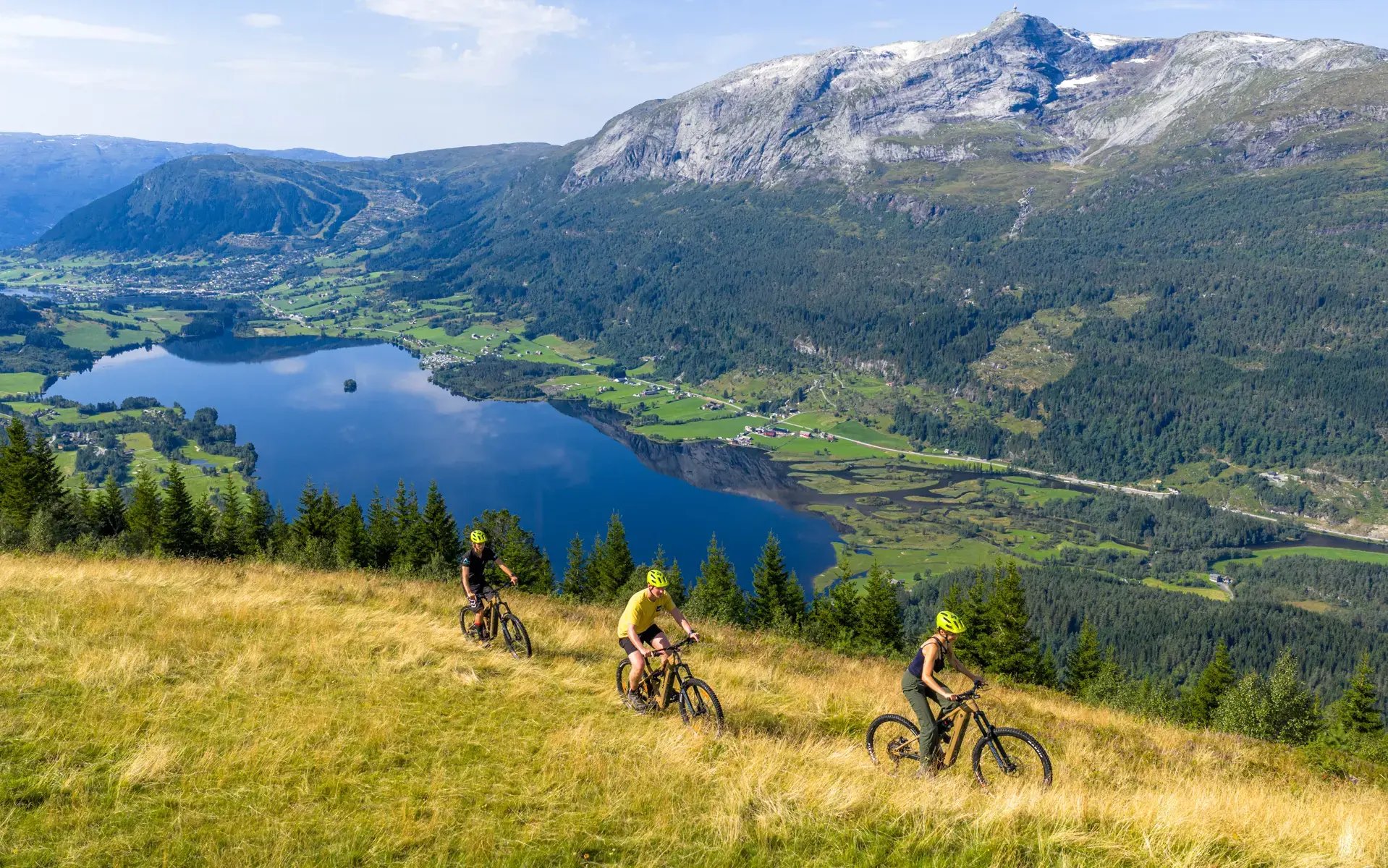 Group of mountain bikers riding high above Hardangerfjord near Voss, Norway