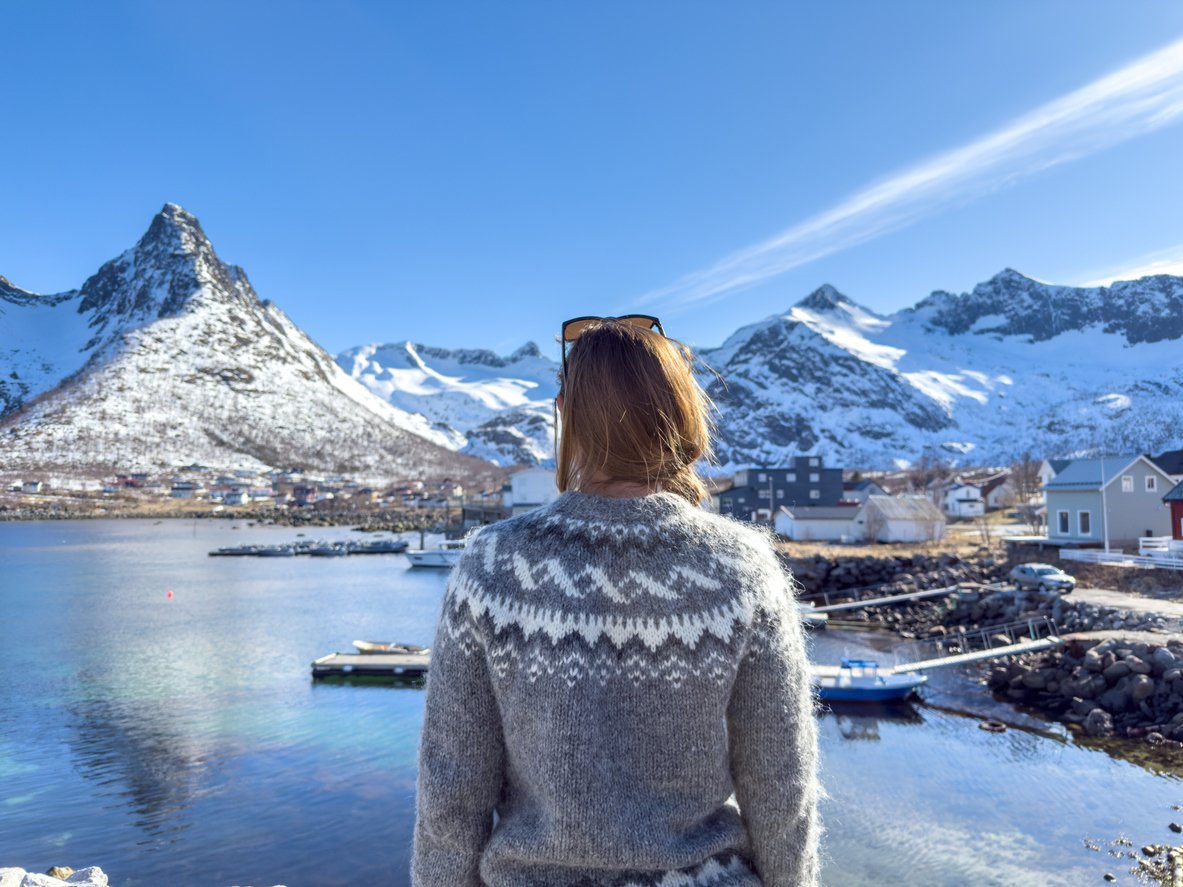 A woman admiring the scenic mountain view of Fjord Norway in the winter