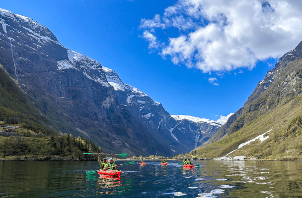 Group of seniors in red kayaks near Hardangerfjord on a guided tour