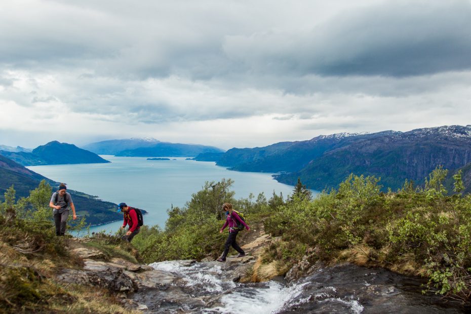 Three hikers exploring the area above the Naeroyfjord, Norway