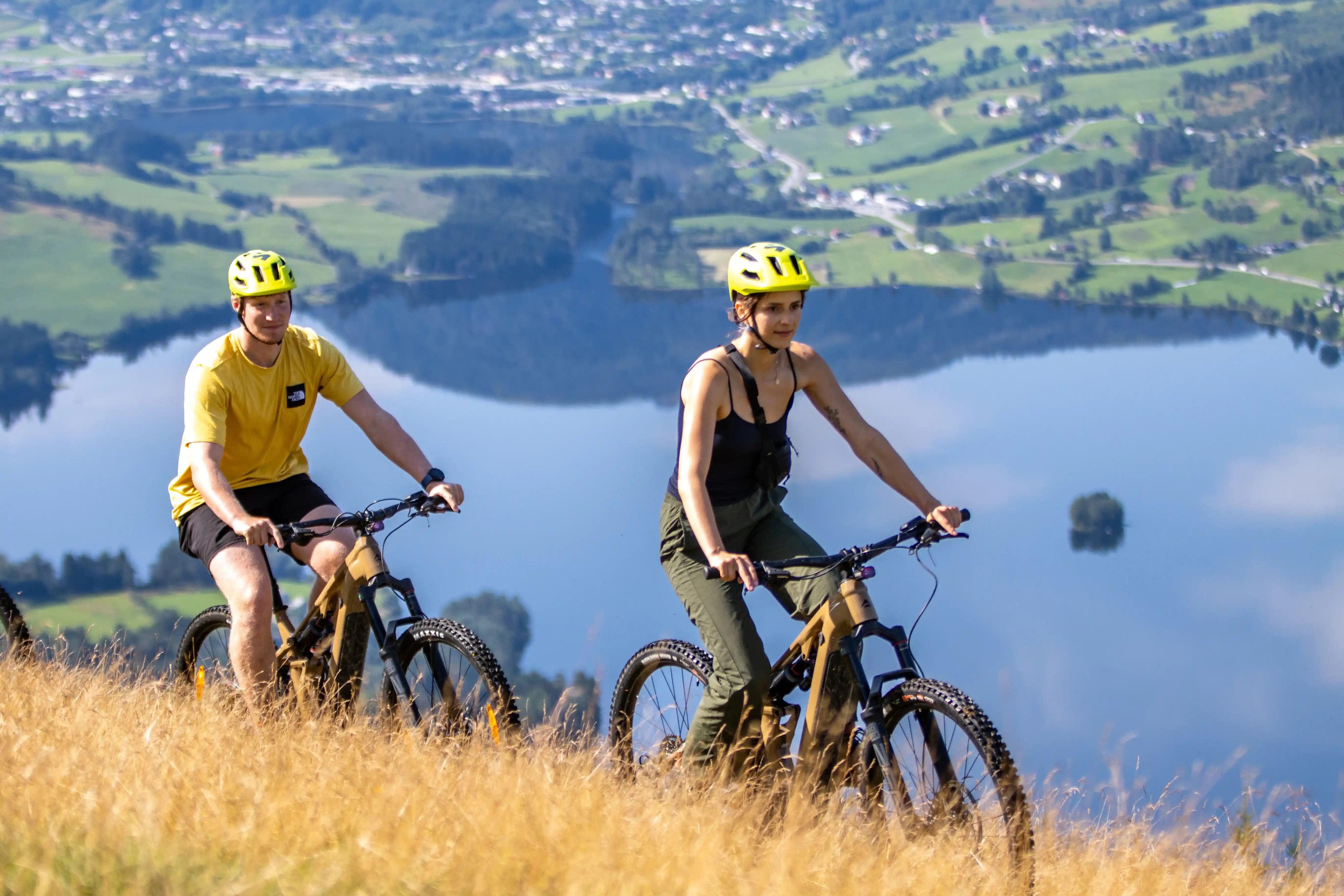 Couple biking above a lake in the Voss area in Norway