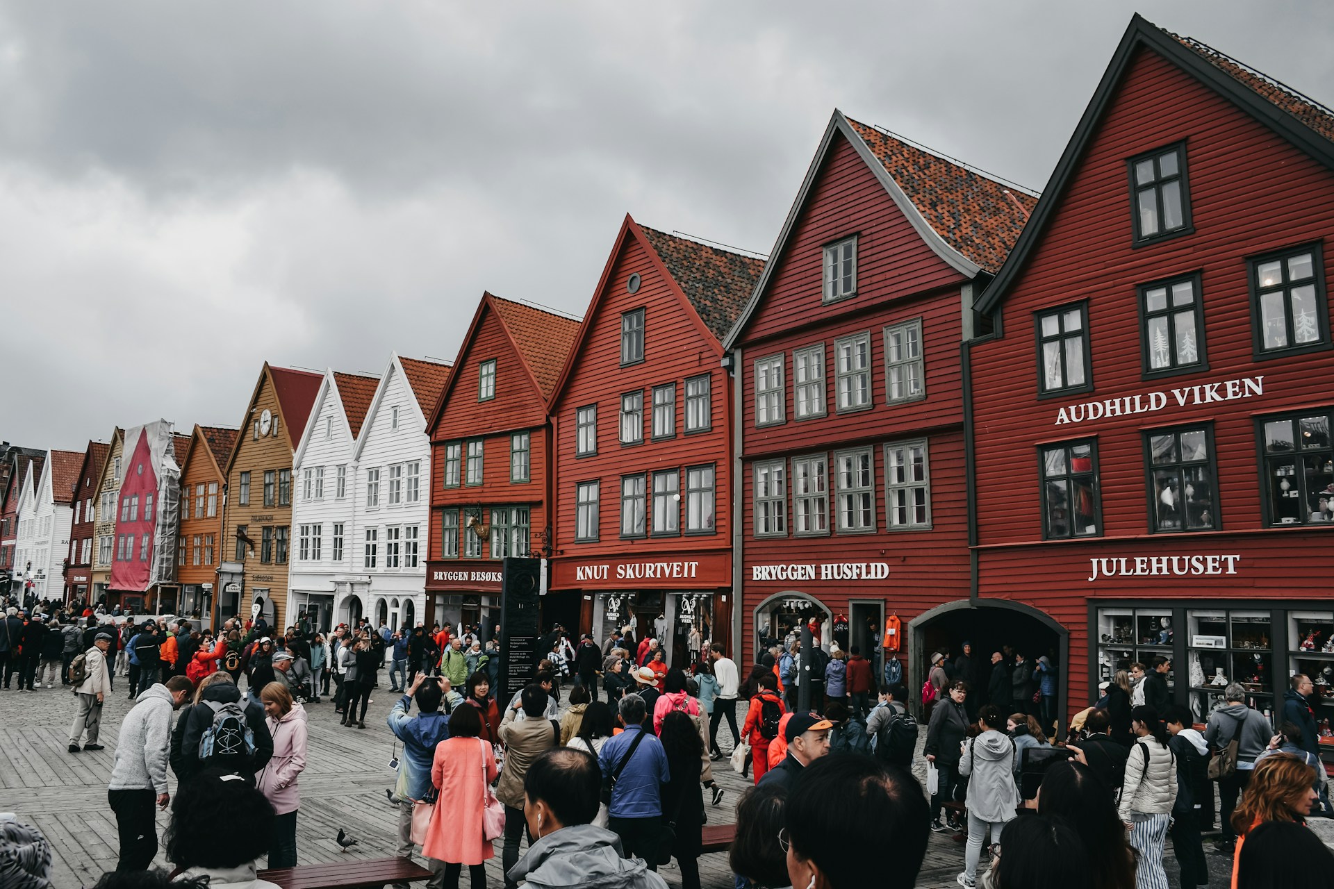Tourists exploring Bergen, Norway, on a cloudy day