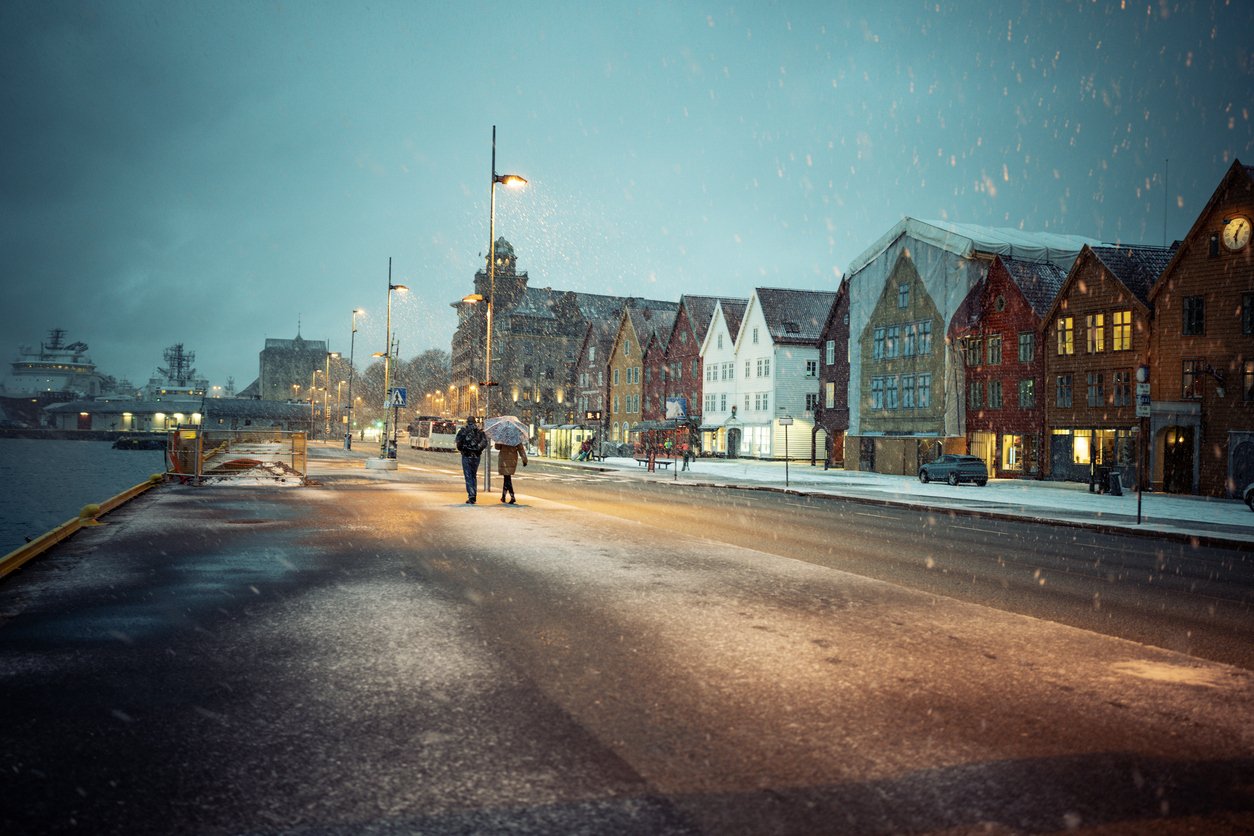 A couple in the snow walking around Bryggen in Bergen, Norway