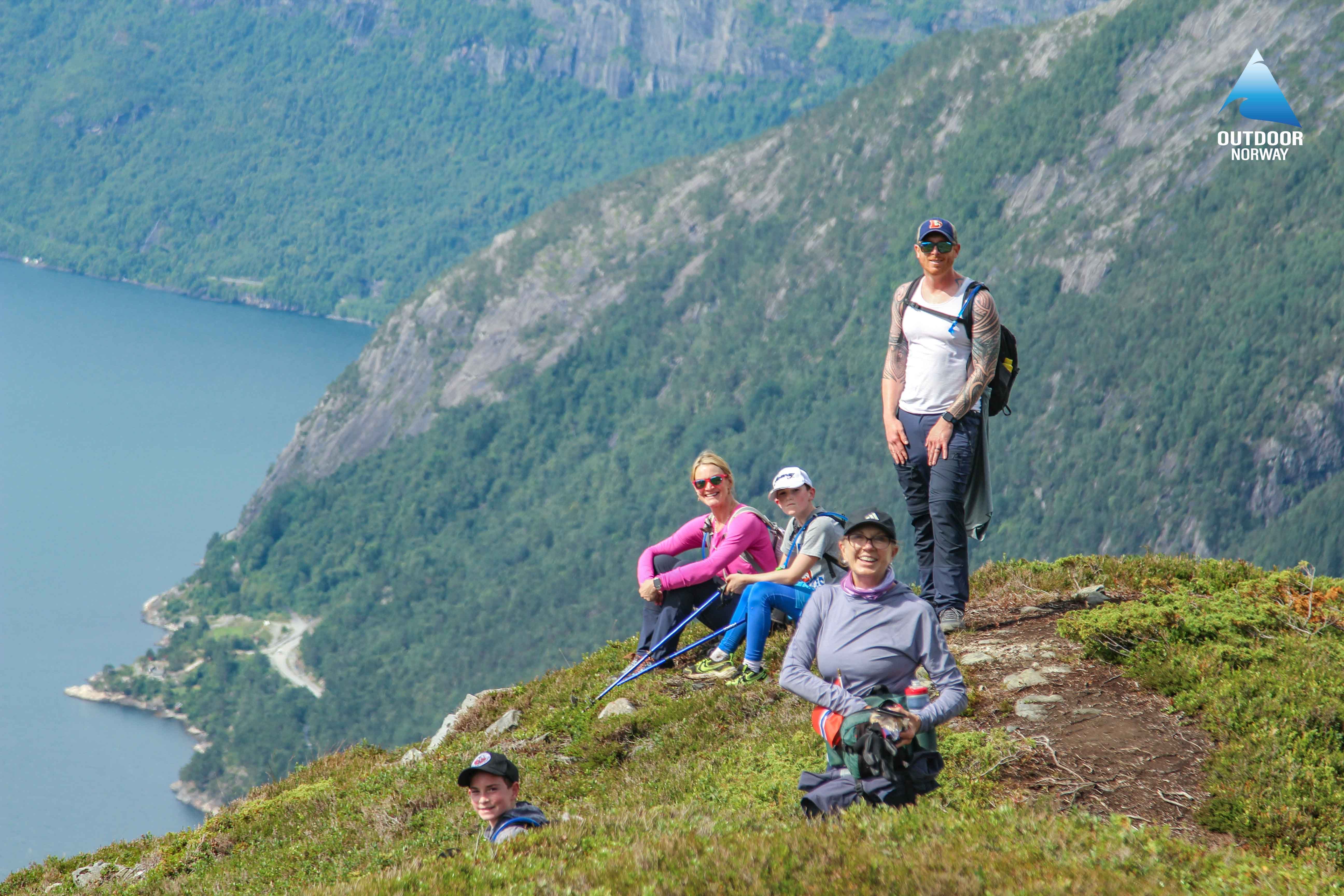Hikers posing on a fjord in the vicinity of Voss, Norway, on a guided tour