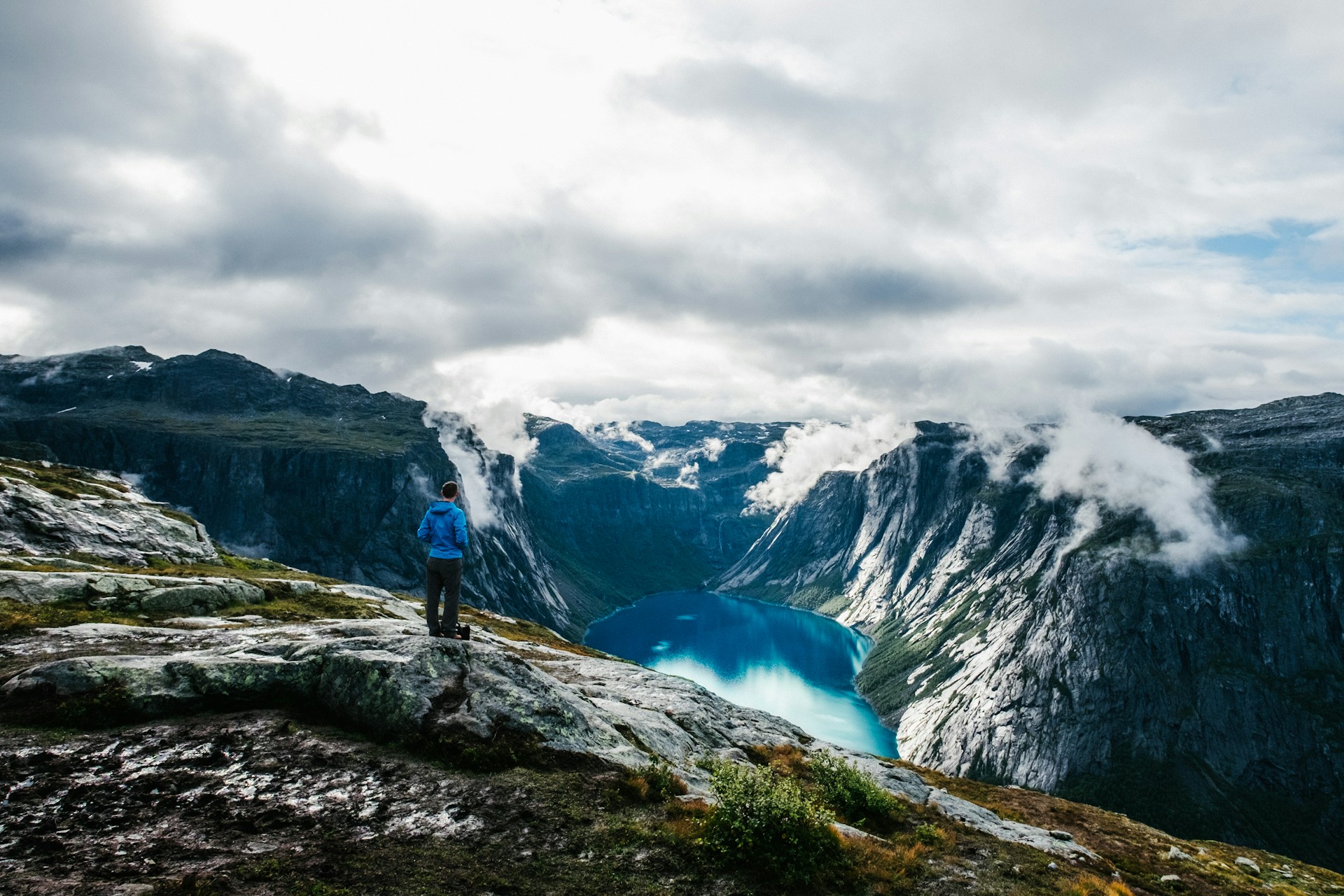 A hiker in Fjord Norway admiring the views on a cloudy day