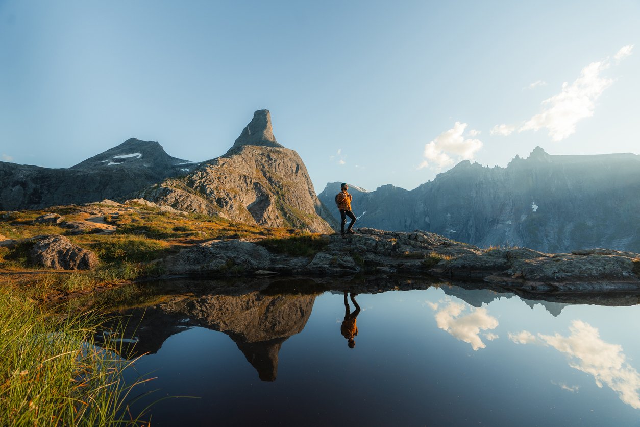 A man hiking with his reflection seen in Fjord Norway, Western Norway