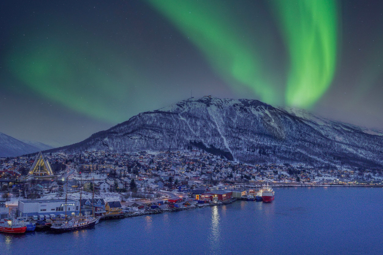 Northern Lights shining over an harbor in Tromsø, Norway