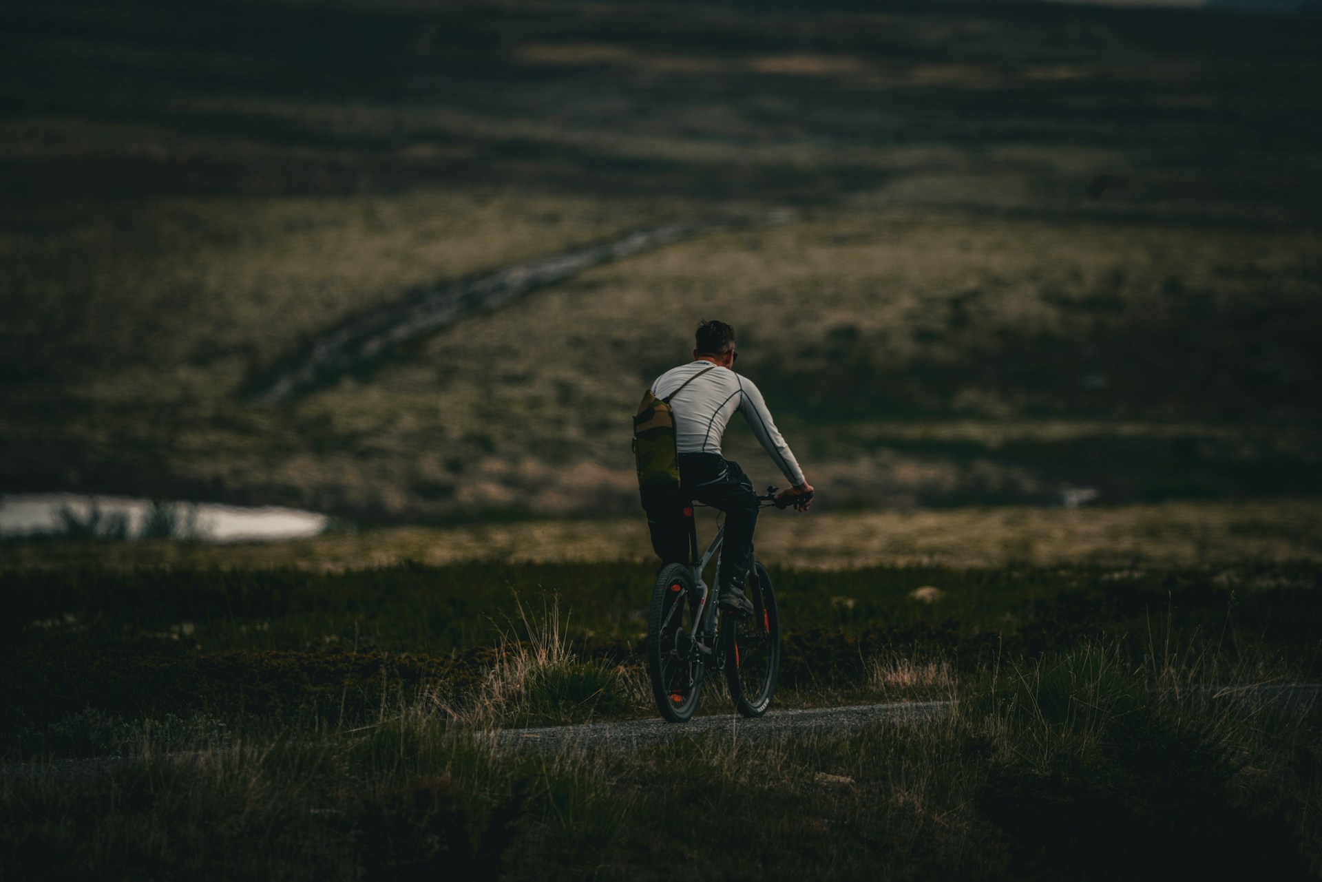A cyclist on a lone road in the Norwegian Highlands