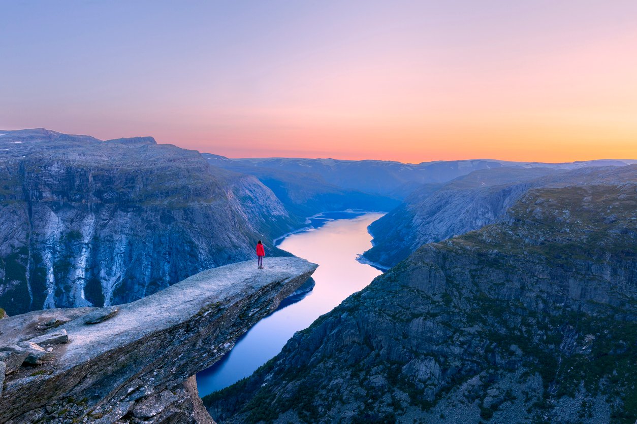 Hiker posing on Trolltunga, the most famous day trip from Bergen, Norway
