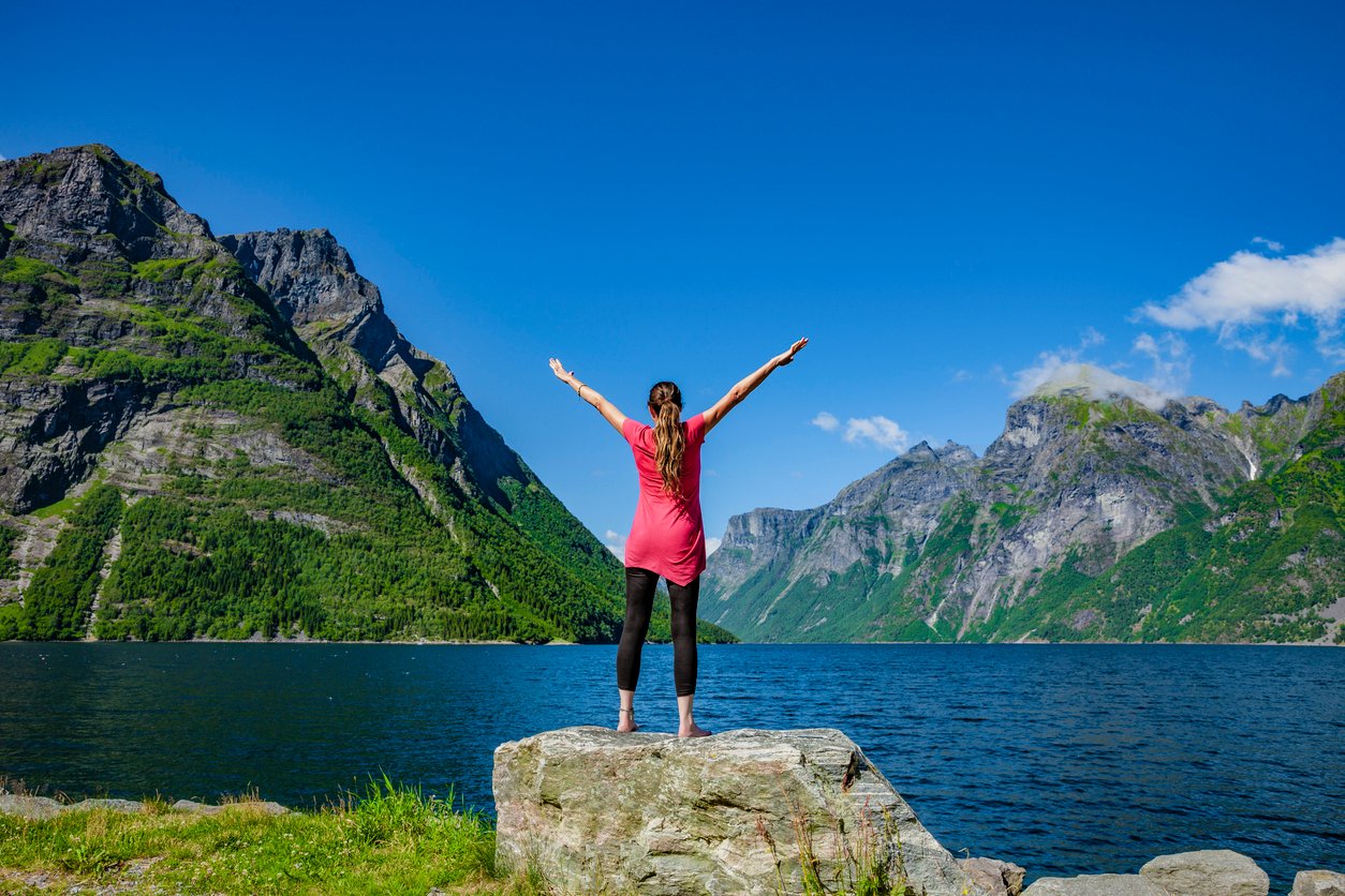 A happy woman enjoying a Hjorundfjord yoga retreat in Norway