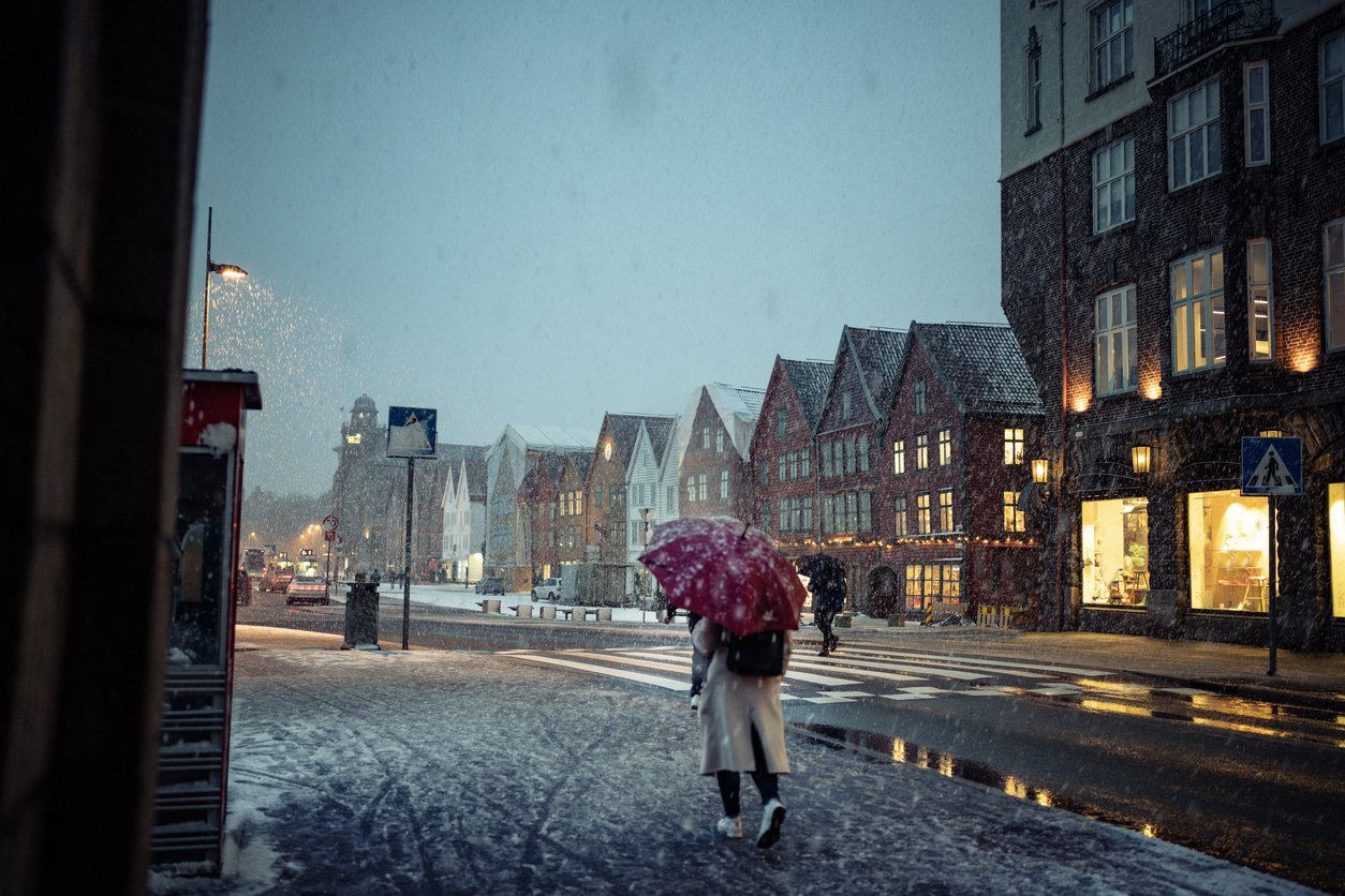 A woman walking through a snow storm in Bergen, Norway
